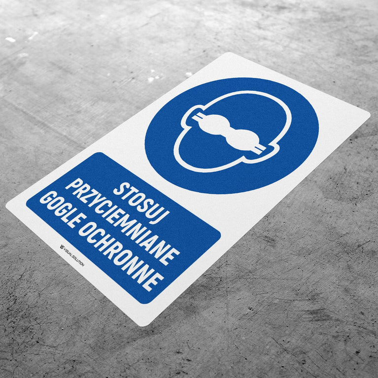 Naklejka podłogowa BHP: Nakaz stosowania przyciemnianych gogli ochronnych z opisem.