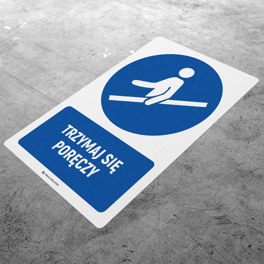 Naklejka podłogowa BHP: Nakaz trzymania się poręczy z opisem.